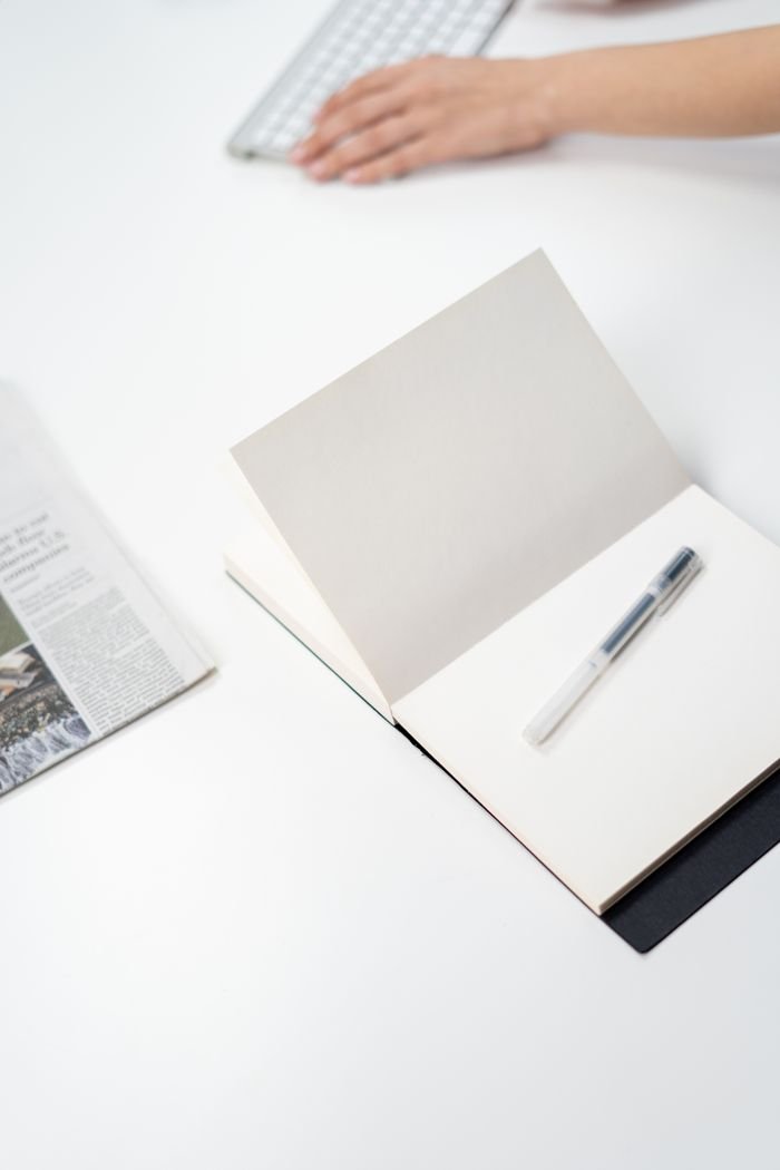 A minimalist workspace featuring a notebook, pen, and keyboard, perfect for freelancers working from home.