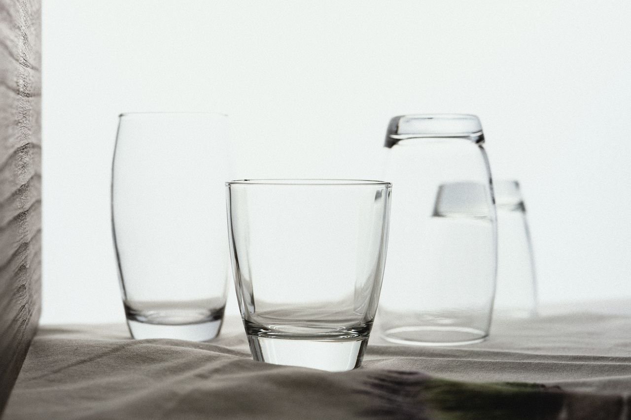 Elegant close-up of various drinking glasses arranged on a smooth fabric surface.